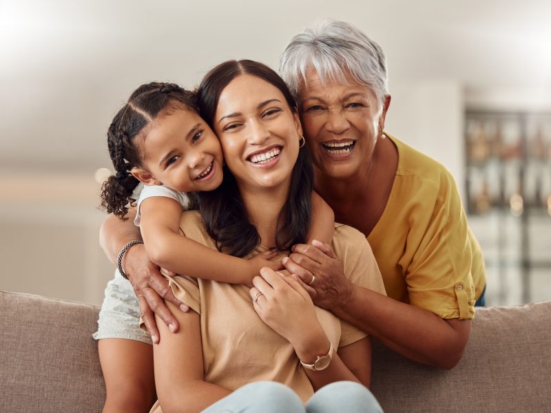 Grandmother, mother, and child hugging together